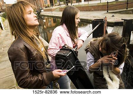 Three teenage girls standing near a canal View Large Photo Image Stock Photograph - Three teenage girls standing near a canal. Fotosearch
