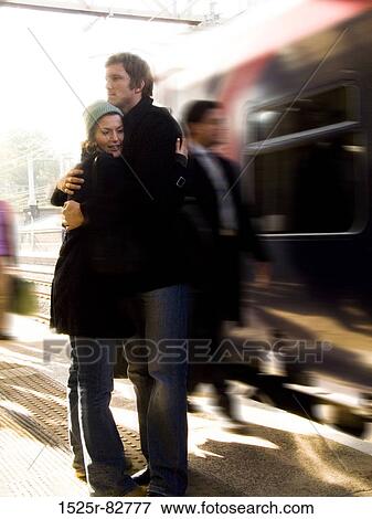 Stock Photo - Young couple embracing each other at a railroad station platform. Fotosearch