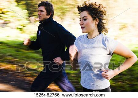 Young couple jogging in a park View Large Photo Image Stock Photograph - Young couple jogging in a park. Fotosearch