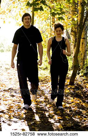Young couple walking in a park View Large Photo Image Stock Photo - Young couple walking in a park. Fotosearch