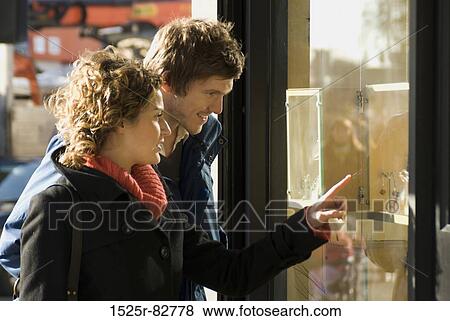 Young couple window shopping and smiling View Large Photo Image Stock Photo - Young couple window shopping and smiling. Fotosearch