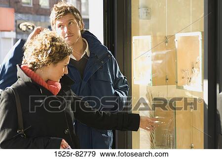 Young couple window shopping View Large Photo Image Stock Photo - Young couple window shopping. Fotosearch