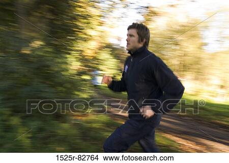 Young man jogging in a park View Large Photo Image Picture - Young man jogging in a park. Fotosearch