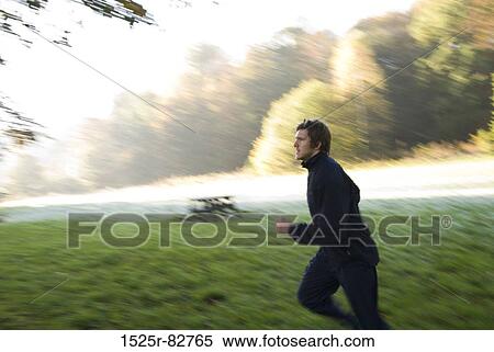 Young man jogging in a park View Large Photo Image Stock Photography - Young man jogging in a park. Fotosearch