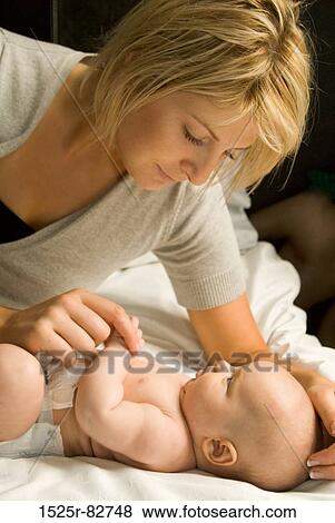 Young woman holding a baby's hand View Large Photo Image Stock Photo - Young woman holding a baby's hand. Fotosearch