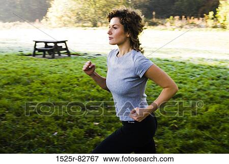 Young woman jogging in a park View Large Photo Image Stock Photo - Young woman jogging in a park. Fotosearch