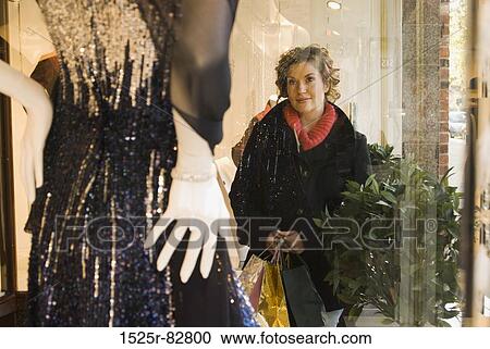 Young woman looking at a mannequin in a shop View Large Photo Image Stock Image - Young woman looking at a mannequin in a shop. Fotosearch