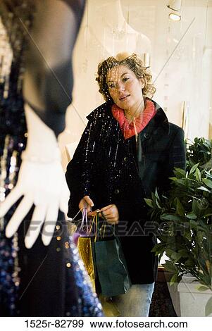 Young woman looking at a mannequin in a shop View Large Photo Image Stock Photo - Young woman looking at a mannequin in a shop. Fotosearch
