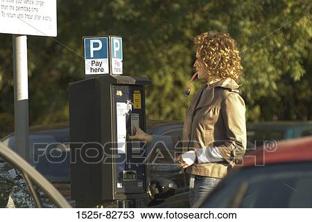 Young woman operating a parking meter View Large Photo Image Stock Image - Young woman operating a parking meter. Fotosearch