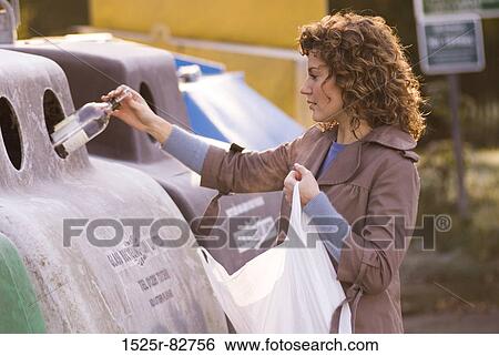 Young woman putting a bottle in a recycling bin View Large Photo Image Stock Photograph - Young woman putting a bottle in a recycling bin. Fotosearch