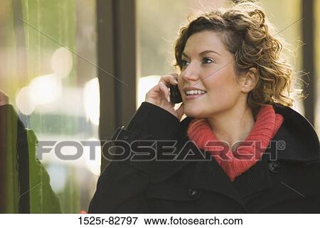 Young woman talking on a mobile phone View Large Photo Image Stock Photo - Young woman talking on a mobile phone. Fotosearch