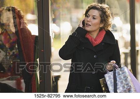 Young woman talking on a mobile phone View Large Photo Image Stock Photography - Young woman talking on a mobile phone. Fotosearch
