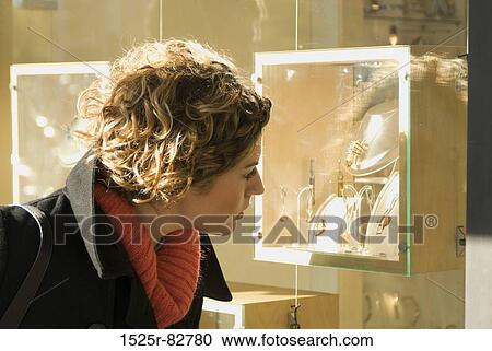 Stock Image - Young woman window shopping. Fotosearch
