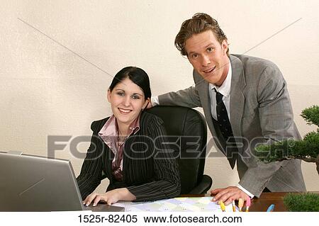 Stock Photography - Businessman and a businesswoman smiling. Fotosearch