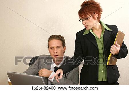 Businessman and his secretary looking at a laptop View Large Photo Image Stock Image - Businessman and his secretary looking at a laptop. Fotosearch