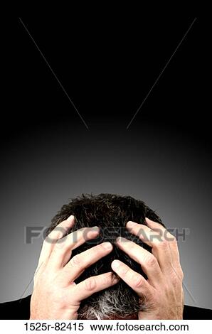 Stock Photography - Businessman holding his head in his hands. Fotosearch