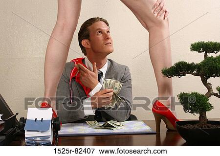 Businessman sitting in an office looking at a woman standing on a desk View Large Photo Image Stock Photo - Businessman sitting in an office looking at a woman standing on a desk. Fotosearch