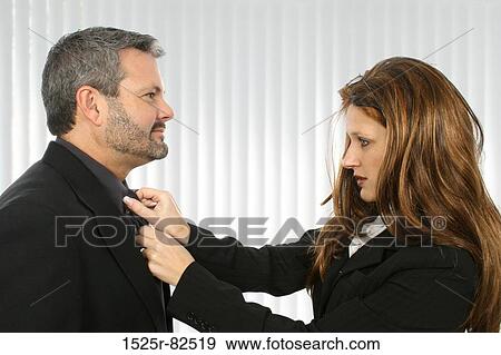 Businesswoman adjusting the tie of a businessman View Large Photo Image Stock Photo - Businesswoman adjusting the tie of a businessman. Fotosearch