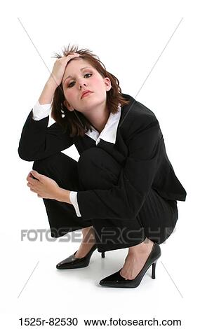Businesswoman crouching with her hand in her hair View Large Photo Image Stock Image - Businesswoman crouching with her hand in her hair. Fotosearch