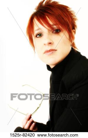 Stock Image - Businesswoman holding eyeglasses and looking serious. Fotosearch