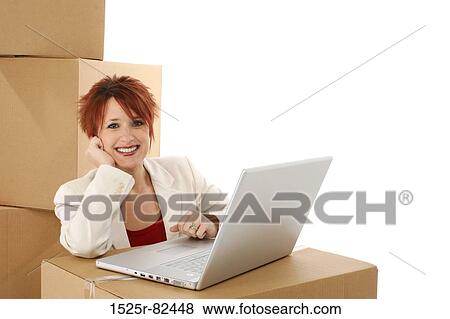 Stock Photo - Businesswoman sitting in front of a laptop and smiling. Fotosearch