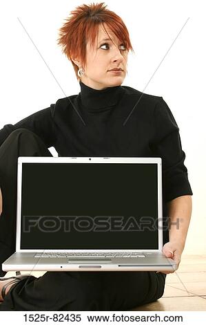 Stock Photography - Businesswoman sitting on the floor holding a laptop. Fotosearch