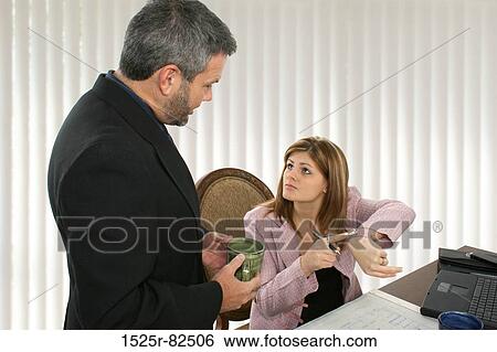 Businesswoman talking to a businessman in an office View Large Photo Image Stock Photograph - Businesswoman talking to a businessman in an office. Fotosearch