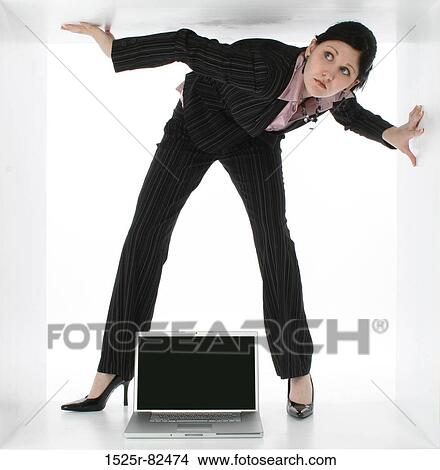 Businesswoman under a low ceiling with a laptop between her legs View Large Photo Image Picture - Businesswoman under a low ceiling with a laptop between her legs. Fotosearch