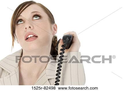 Close-up of a businesswoman holding a telephone receiver and looking up View Large Photo Image Stock Photo - Close-up of a businesswoman holding a telephone receiver and looking up. Fotosearch