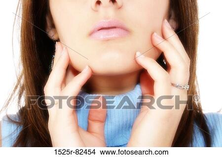Picture - Close-up of a young woman touching her face. Fotosearch