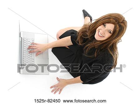 Stock Image - High angle view of a businesswoman working on a laptop and smiling. Fotosearch