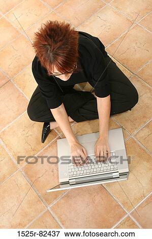 High angle view of a businesswoman sitting on the floor and working on a laptop View Large Photo Image Stock Photo - High angle view of a businesswoman sitting on the floor and working on a laptop. Fotosearch