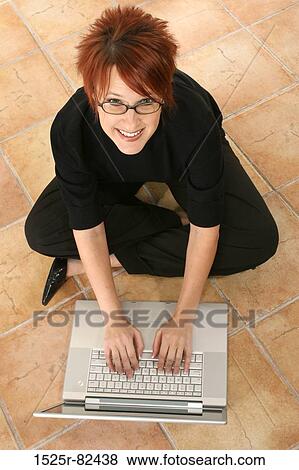 High angle view of a businesswoman sitting on the floor and working on a laptop View Large Photo Image Stock Photo - High angle view of a businesswoman sitting on the floor and working on a laptop. Fotosearch