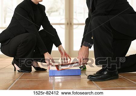 Low section view of a businessman and a businesswoman picking up notebooks from the floor View Large Photo Image Stock Image - Low section view of a businessman and a businesswoman picking up notebooks from the floor. Fotosearch
