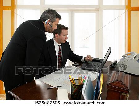 Two businessmen looking at a laptop View Large Photo Image Stock Photography - Two businessmen looking at a laptop. Fotosearch