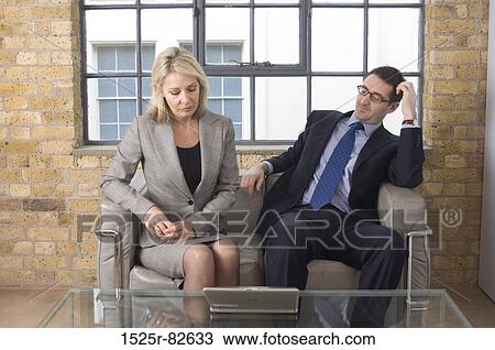 Businessman and a businesswoman sitting on a couch View Large Photo Image Stock Image - Businessman and a businesswoman sitting on a couch. Fotosearch