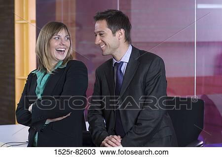 Businessman and a businesswoman smiling in an office View Large Photo Image Stock Image - Businessman and a businesswoman smiling in an office. Fotosearch