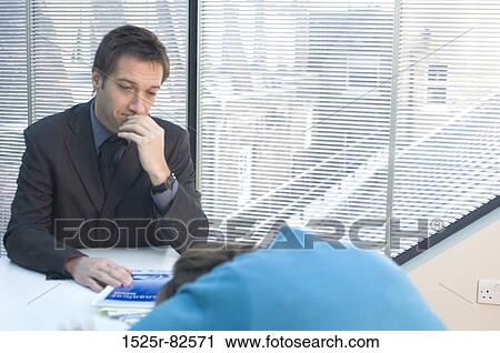 Businessman looking at a mid adult woman sleeping at a desk View Large Photo Image Stock Image - Businessman looking at a mid adult woman sleeping at a desk. Fotosearch