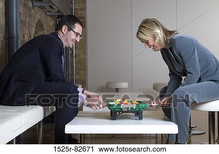 Businessman playing foosball with a businesswoman View Large Photo Image Stock Image - Businessman playing foosball with a businesswoman. Fotosearch