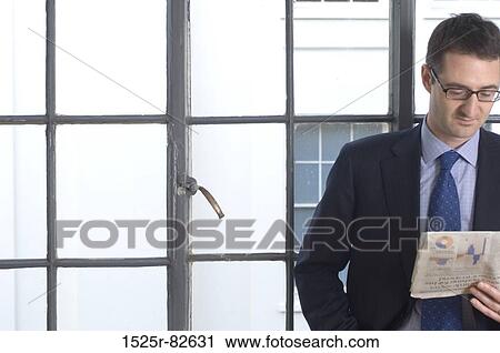 Stock Image - Businessman reading a newspaper. Fotosearch