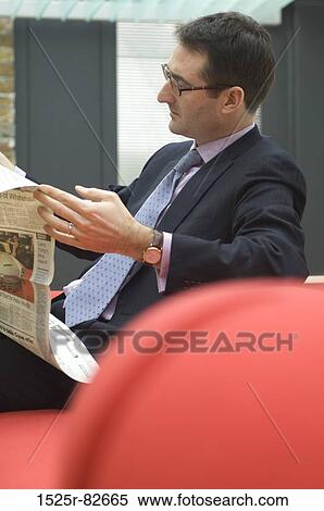 Businessman reading a newspaper View Large Photo Image Stock Photography - Businessman reading a newspaper. Fotosearch