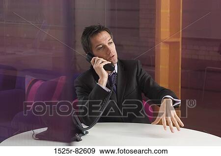Businessman talking on the telephone in an office View Large Photo Image Stock Photo - Businessman talking on the telephone in an office. Fotosearch