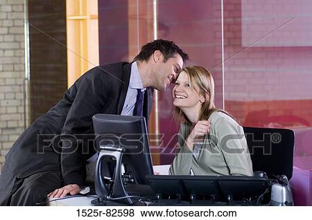 Businessman whispering into a businesswoman's ear View Large Photo Image Stock Photo - Businessman whispering into a businesswoman's ear. Fotosearch