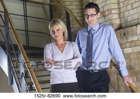 Businessman with a businesswoman standing on a staircase View Large Photo Image Stock Image - Businessman with a businesswoman standing on a staircase. Fotosearch