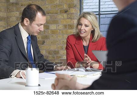 Businessman with a businesswoman looking at documents in an office View Large Photo Image Stock Photo - Businessman with a businesswoman looking at documents in an office. Fotosearch