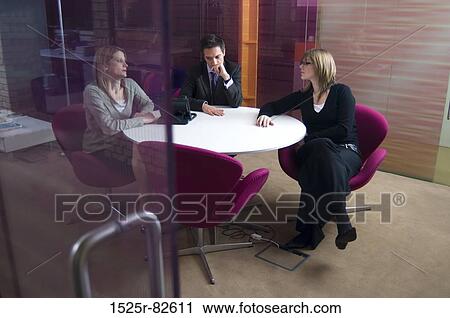 Businessman with two businesswomen talking in an office View Large Photo Image Stock Image - Businessman with two businesswomen talking in an office. Fotosearch