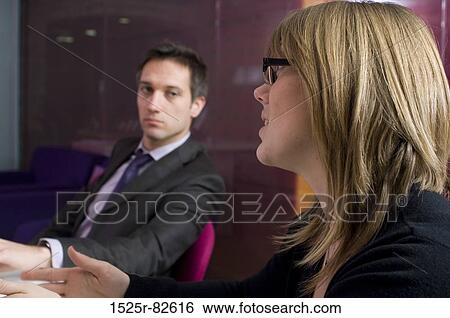 Businesswoman and a businessman talking in an office View Large Photo Image Stock Photograph - Businesswoman and a businessman talking in an office. Fotosearch