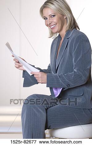 Businesswoman holding a document and smiling View Large Photo Image Stock Photo - Businesswoman holding a document and smiling. Fotosearch
