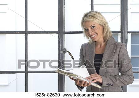 Businesswoman holding documents and smiling View Large Photo Image Stock Image - Businesswoman holding documents and smiling. Fotosearch