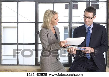 Businesswoman showing documents to a businessman View Large Photo Image Stock Photography - Businesswoman showing documents to a businessman. Fotosearch
